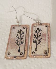 These silver plated (treated to deter tarnish) 3-D earrings are approximately 1 1/4 inch in length and 5/8 inch wide.  They are backed with gold plate, in the style of slightly distressed and the back of these earrings are plain.  All earrings have sterling silver (.925) fishhook fasteners and all fishhooks come with a clear, rubber earring back. Nickel-free Rectangular Metal Earrings, Stamped Metal Earrings For Gifts, Fish Hook, Earring Backs, Silver 925, Jewelry Earrings Dangle, Silver Plate, Silver Earrings, 3 D