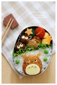 a bento box filled with rice, meats and veggies in the shape of animals