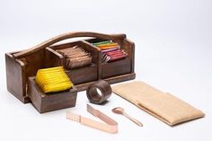 a wooden box with tools in it on a white surface and some other items nearby