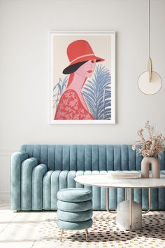 a living room with blue velvet couches and a round table in front of a painting on the wall