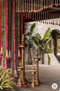 an outdoor area with candles, flowers and beads hanging from the ceiling in front of it