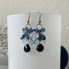 This is a variation of my waterfall earrings. Instead of individual chandelier pendants, these gemstones are assembled in a lovely cluster cascading from the circle. These beautiful earrings consists of some of the most gorgeous gemstones. This collection includes blue sapphire, sky blue topaz, rainbow moonstone, holly blue chalcedony, Ceylon sapphire, mystic Swiss blue topaz, kyanite and iolite. The focal sapphire measures approximately 11 mm wide and 10 mm long. All of these gemstones are high