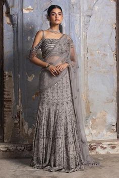 Grey georgette draped lehenga saree embroidered in gun metal and silver dori, beads and crystals. Paired with net cold shoulder blouse.
Components: 2
Pattern: Embroidered
Type Of Work: Bead,Dori,Crystals
Neckline: Asymmetric
Sleeve Type: Sleeveless
Fabric: Saree: Georgette, Blouse: Net and Lining: Shantoon
Color: Grey
Other Details: 
Net palla
Faux feather border
Occasion: Cocktail,Reception - Aza Fashions Drape Lehenga, Drop Shoulder Blouse, Net Blouse, Draped Saree, Grey Saree, Net Blouses, Bridal Lehenga Red, Drape Saree, Indian Wedding Wear