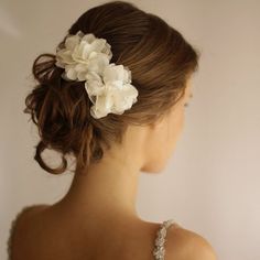 a woman with flowers in her hair is wearing a dress and looking off to the side