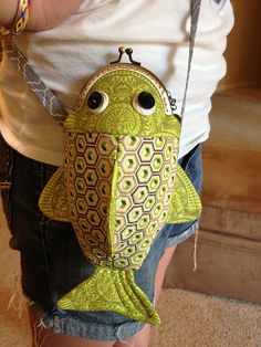 a woman is holding a purse with a fish on it