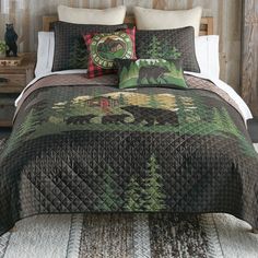 a bed covered in a green and brown quilt