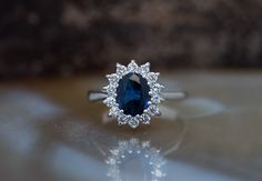 a ring with a blue stone surrounded by diamonds