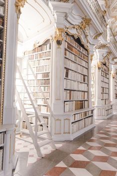 an ornate library with many bookshelves and stairs