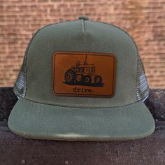 "Drive", mesh adjustable snapback hat Does your kid love tractors? In pairing original artwork with a leather patch and high quality craftsmanship, the hat is perfect for all your days on the farm! **SIZING INFO** Fits 18"-21" head circumference and have a mesh backing. The adjustable straps fit head circumference of 18-21 inches and fit best on ages three and up. Measure your child's head circumference to be sure! Every child is different. WHAT MAKES US DIFFERENT - We are a family company, woman and mom owned! - Our designs are all original artwork created from the inspiration we draw from our outdoor-loving kids! - Our clothing is hand-printed in small batches in our shop right in Western North Carolina. - Our clothing is made with a polyester/cotton blend that is SUPER SOFT and durable. Adjustable Trucker Hat With Leather Patch, Tractor Hat, Hat For Kids, Farm Kids, Bf Gifts, Farm Tractor, Kids Hats, Head Circumference, Leather Patches