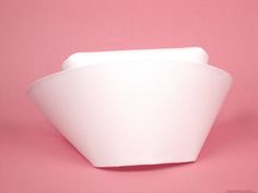 a white bowl sitting on top of a pink surface