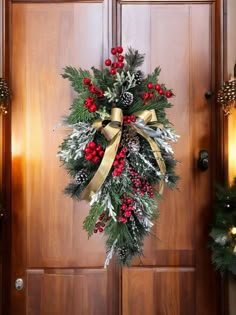 a christmas wreath on the front door of a house with pine cones, holly and red berries