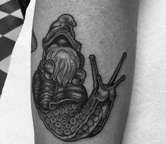 a black and white photo of a snail tattoo