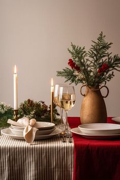 a table set for christmas with wine glasses and plates