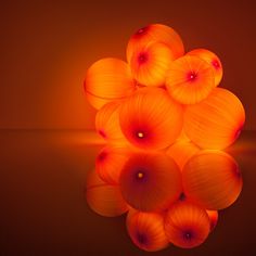 a bunch of orange balls sitting in the middle of a room with an orange light behind them