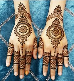 two hands with henna tattoos on them