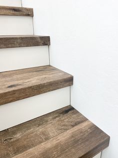 a set of wooden stairs with white painted walls