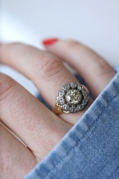 Antique engagement daisy ring in 18kt yellow gold and silver. (hallmark: owl and swan) Delicately chiseled setting, adorned in its center with an old-fashioned cut diamond, weighing approximately 0.85 Ct (Estimated color K, estimated clarity P) in an entourage of rose-cut diamonds (weighing in total approximately 0.20 Ct ). 19th century work. Gross weight: 4.90g Ring size: 52 (diameter 16.50 / US 6.00). Pattern height: 1.40 cm Condition: micro scratches and oxidation on the gold and silver parts Antique Gold Cluster Ring With Center Stone, Vintage Gold Wedding Ring With Halo Setting, Daisy Engagement Ring, Daisy Ring, Antique Engagement, Shiny Things, Rose Cut Diamond, Vintage Diamond, Cluster Ring