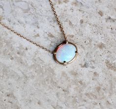 "Every Opal is Unique in its own way. Each stone has its own color variation, showing off hints of blue, purple, pink, green and red. - Oval Australian Opal measures 8 x 10mm - Choose your length: 14\" - 15\" - 16\" - 17\" - 18\" - Available in rose, white or yellow gold Processing times - Current processing time is 1 - 3 weeks. Each Item is handmade to order with love and care! In Stock Items - Contact Liesel Love with any rush order questions, or to see if we have anything ready made and in st Fine Jewelry Opal Oval Necklace, Oval Opal Necklace Fine Jewelry, Fine Jewelry Opal Necklace Oval Shape, Opal Cabochon Round Pendant Necklaces, Opal Cabochon Round Pendant Necklace, Opal Birthstone Necklace With Oval Pendant, Opal Oval Cabochon Gemstone Necklace, Opal Gemstone Necklace With Oval Cabochon, Ethiopian Opal Cabochon Oval Pendant