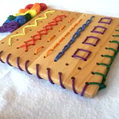 a wooden board with colorful stringing on it