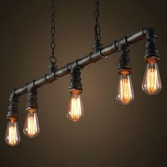 three light bulbs hanging from the ceiling in an industrial style chandelier with metal pipes and