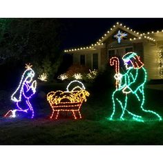 christmas lights in front of a house with nativity scene