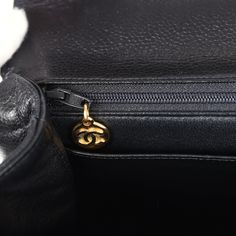 This vintage Chanel Kelly Top Handle Flap Bag is in black caviar leather with gold hardware, featuring the signature CC turnlock closure with front flap, half moon back pocket and a black rolled top handle.The interior is lined in black leather and includes one zip pocket with logo pull and a slip pocket underneath on the rear wall.Collection: 4-series (1996-1997)Origin: FranceCondition: Vintage; Excellent to Mint - This bag retains its structure. There is no plastic on the hardware which shows moderate scratching. There's some light creasing to the exterior leather but not other signs of wear. The interior is clean with a few small press markings to the interior base. Date stamp sticker is still intact.Accompanied by: Chanel box, dustbag, carebook, COA cardMeasurements: 12" width x 9" hei Chanel Kelly, Date Stamp, Chanel Box, Black Caviar, Celine Bags, Carry All Bag, Black Excellence, Vintage Chanel, Fendi Bags