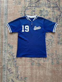 Vintage blue mesh baseball jersey. White and blue stripe trim. Sooke - BC. Number 19. 100% polyester. Size small. Measurements: Chest- 17.25" Sleeves- 8.75" Length- 24" All measurements taken flat and not doubled. Cheap Blue College Baseball Jersey, Cheap Blue Baseball Jersey With Graphic Print, Sooke Bc, Number 19, Trap House, Vintage Jerseys, Baseball Jersey, Baseball Jerseys, Fancy Dresses