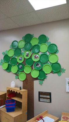 a tree made out of green plates on the wall