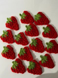 knitted strawberries arranged in rows on white surface