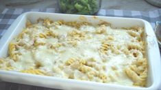 a casserole dish with noodles and cheese on the table next to a jar of broccoli