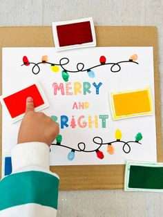 a child's hand is stamping merry and bright on a christmas card