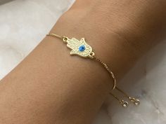 Hamsa Hand gold plated and turquoise evil eye protection adjustable slider bracelet with rhinestone ends Perfect for stacking bracelets Gold plated brass Hamsa charm size approximately 21 mm x 13 mm Every order comes in our luxury matt frosted recyclable logo pouch, which are also available to purchase separately for any extra pieces you may want to store with style. Gift wrap sets (box & faux leather pouch)  are available at checkout and available to buy separately. Braclets Gold, Evil Eye Protection, Hamsa Charm, Protection Bracelet, Gold Plated Bracelets, Hamsa Hand, Eye Protection, Leather Pouch, Bracelet Stack