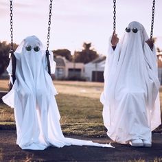 two children dressed as ghostes on swings