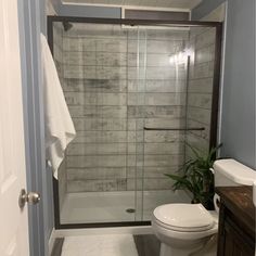 a white toilet sitting next to a walk in shower