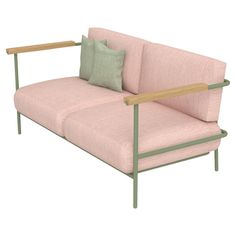 a pink couch with two green pillows on it's arms and backrests