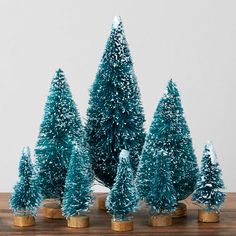 small blue christmas trees are sitting on a table