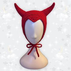 a red knitted hat with horns on top of a mannequin's head