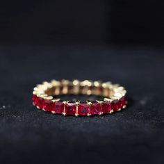 a gold ring with three rows of red stones