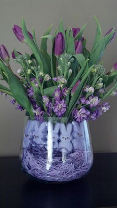 a vase filled with purple flowers on top of a table