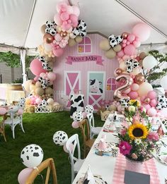 a pink and white farm themed party with balloons in the shape of cow's head