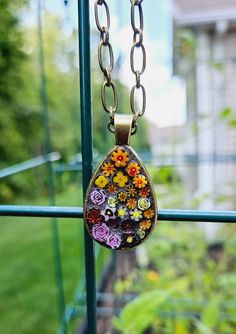 a necklace with flowers on it hanging from a window sill