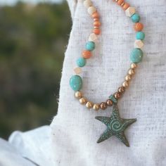 Boho Style Necklace With Bleached Wood Beads, Turqouise Stones, Orange Wood Beads And Orange Stone Beads. Accents Of Copper And Gold . Necklace Length 28" With Pendant Adding An Additional 3" Bohemian Star Beaded Necklaces For Jewelry Making, Bohemian Star Shaped Beaded Necklaces For Gifts, Bohemian Star-shaped Beaded Necklaces, Bohemian Star-shaped Beaded Necklace, Ocean-inspired Starfish Charm Beaded Necklace, Bohemian Beaded Necklaces With Starfish Charm, Bohemian Beaded Necklace With Starfish Charm, Ocean-inspired Starfish Beaded Necklace For Beach, Handmade Adjustable Starfish Beaded Necklace