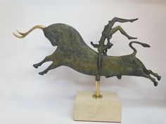 a bronze sculpture of a running horse on a marble base