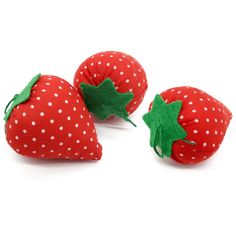 three stuffed strawberries with green leaves on them