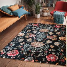 a black rug with flowers on it in front of a couch and bookshelf