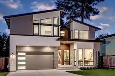 a two story house with an attached garage and large windows on the front of it