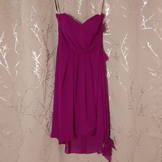 a purple dress hanging on a white wall