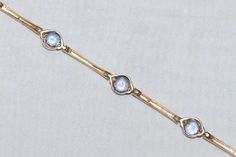 14 KT yellow gold bracelet with round lab created bezel set tanzanite gemstones. This bracelet is measured 7 inches long with a classic lobster clasp and is weighted 6.1 grams. The bracelet is hallmarked 14 K gold and has also been checked for authenticity. Gold Tanzanite Jewelry With Bezel Setting, Elegant Tanzanite Bracelets For Formal Occasions, Round Tanzanite Bracelets For Formal Occasions, Classic Gold Tanzanite Jewelry, Formal Tanzanite Round Bracelets, Formal Faceted Tanzanite Jewelry, Gold Tanzanite Jewelry With Faceted Design, Gold Bracelet With Bezel Setting For Formal Events, Elegant Adjustable Tanzanite Jewelry