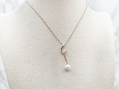 What a lovely combination! Looping yellow gold, sparkling diamonds, and a white saltwater pearl create a gorgeous profile in this modernist pendant. Perfect for layering, this would make a unique accessory for a bride on her wedding day!This pendant does not come with the chain shown. Please feel free to contact us, we will help you find the perfect chain for your style and budget!Metal: 14K Yellow GoldGem: Saltwater PearlGem Measurements: 7.5 mmAccents: 9 Diamonds totaling .10 Carats, SI in Clarity, G in ColorMeasurements: 8 x 37 mmMarks: "14KT SGS" Stamped on the reverse Diamond Drop Pendant, Saltwater Pearls, Diamond Drops, Drop Pendant, Sparkle Diamonds, Accessories Unique, Swirl, Layering, Wedding Day