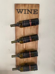 a wooden wine rack with four bottles on it